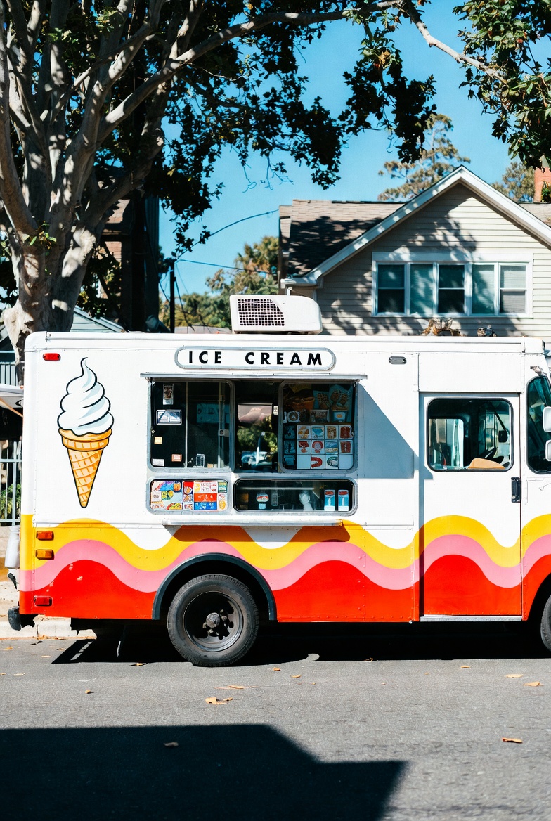 A brightly branded ice cream truck serving frozen treats to families at a neighborhood park on a warm day